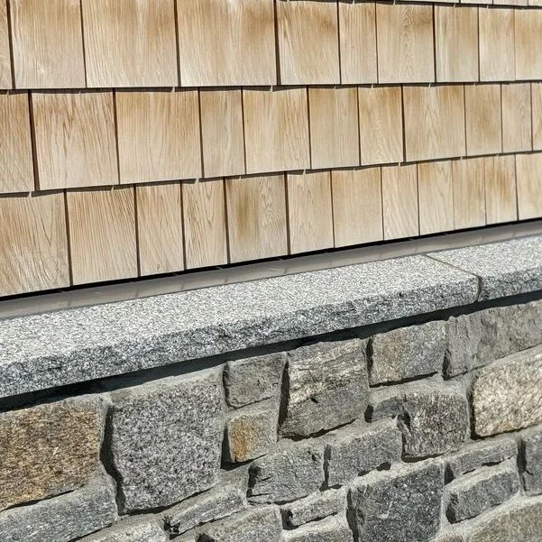 stone accent wall with wood shaker siding close up view